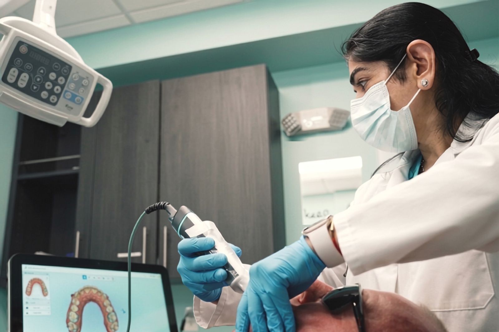 Dr. Uttma Dham taking a digital intraoral scan of a patient's teeth